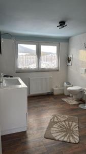 a bathroom with a sink and a toilet and two windows at FeWo ,Sonnenschein ,Sollstedt in Sollstedt +13 photos