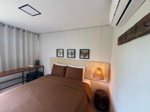 a bedroom with a bed and a desk with a lamp at Oby Noronha in Fernando de Noronha