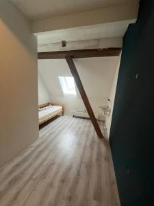 an attic room with wooden floors and a window at Pension Veldzigt in Wijnaldum +7 photos