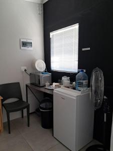 a kitchen with a refrigerator and a table with a window at Silwerrand in Beaufort West