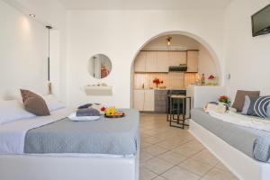two beds in a room with a kitchen at Little Yard Studios & Apartments #6 in Naxos Chora