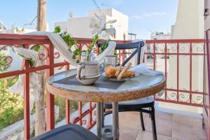 a small table with a plate of food on a balcony at Little Yard Studios & Apartments #6 in Naxos Chora