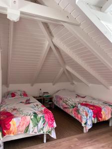 two beds in a room with a attic at La Maison du Bonheur in Pointe-Noire +5 photos