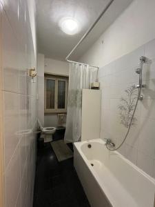 a bathroom with a tub and a toilet and a sink at CozyNeat Hub in Turin +30 photos