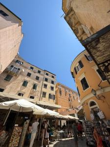 a group of people walking around a market with umbrellas at Vistas Venecianas Apartment Corfu Old Town in Corfu