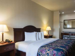 a hotel room with a bed and two lamps and a phone at HiWay Inn Express in Coalgate