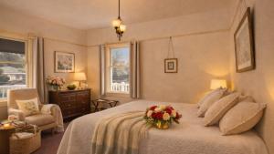 a bedroom with a bed with a bouquet of flowers on it at Tomales Hotel, Minutes from Dillon Beach in Tomales