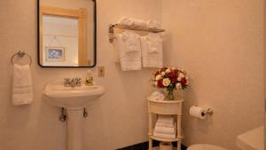 a bathroom with a sink and a mirror and towels at Tomales Hotel, Minutes from Dillon Beach in Tomales