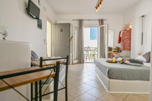 a bedroom with a bed and a table and a balcony at Little Yard Studios & Apartments #6 in Naxos Chora