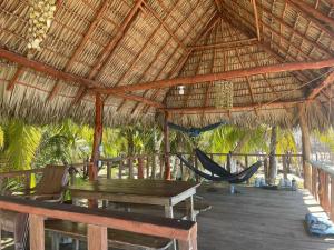 a hammock in a straw hut with a hammock at The Chill Inn in Jiquilillo