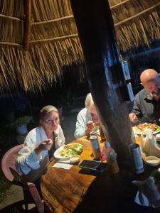 a group of people sitting at a table eating food at The Chill Inn in Jiquilillo