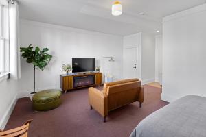 a living room with a couch and a tv and a chair at Tomales Hotel, Minutes from Dillon Beach in Tomales