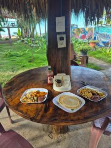 a wooden table with plates of food on it at The Chill Inn in Jiquilillo +15 photos
