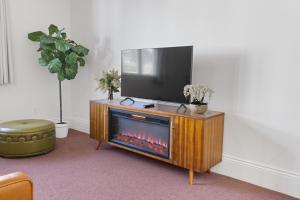 a television on top of a wooden entertainment center with a fire place at Tomales Hotel, Minutes from Dillon Beach in Tomales +16 photos