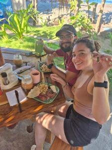 a man and a woman sitting at a table eating food at The Chill Inn in Jiquilillo