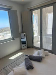 a room with two towels and a mirror and windows at Aetheria Apartment with Private Pool in Kampos Paros