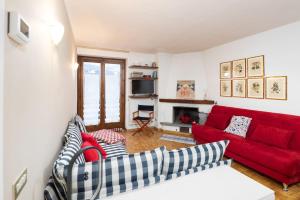 a living room with a red couch and a fireplace at Bormio's Balcony - At the Spa in Premadio