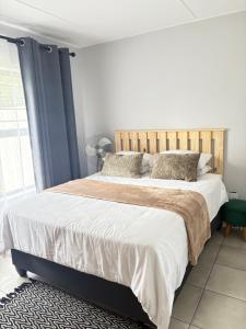 a bedroom with a large bed with a wooden headboard at Monochrome View in Nelspruit