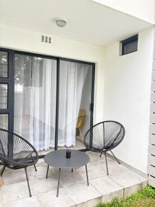 a patio with two chairs and a table at Monochrome View in Nelspruit