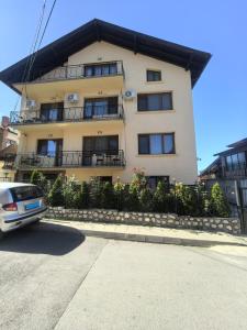 a building with a car parked in front of it at Tsvetkovi Guest House in Dobrinishte