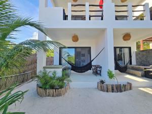 a villa with a hammock in the middle of a house at Casa del Mar Holbox in Holbox Island