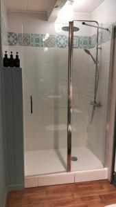 a shower with a glass door in a bathroom at Monsieur Morgan's in Féniers