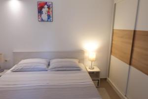 a bedroom with a bed and a lamp on a table at Apartment Marija in Premantura