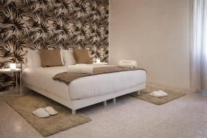 a bedroom with a bed with white shoes on the floor at Ca' De Amicis Rho Fiera Milano - Private parking - Self check in in Rho