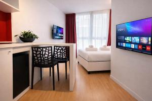 a living room with a table and chairs and a television at Citizen Suites Asignatures by Dahlia in Sliema