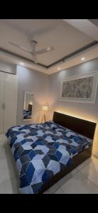 a bedroom with a blue and white comforter on a bed at The dream studio in Noida