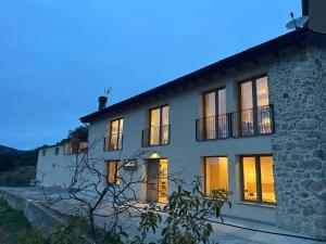 a large white house with its lights on at Cal Rocamartí, Turisme Rural - Montant de Tost, Pirineu in Montant