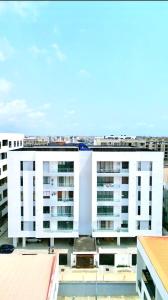 a large white building in a city with buildings at Luxury 2 Bedroom Apartment with 2 Private Patios in Lekki Phase 1 in Lekki