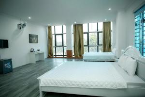 a white bedroom with a large bed and windows at Nice's Hotel Ninh Binh in Ða Gia