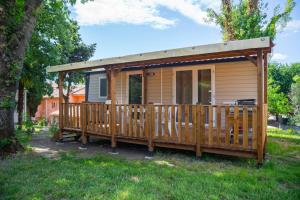 a tiny house with a porch and a deck at Camping Parc Bellevue in Cannes