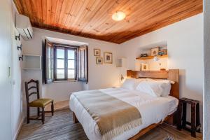 a bedroom with a large bed and a wooden ceiling at The Place at Evoramonte in Évora Monte