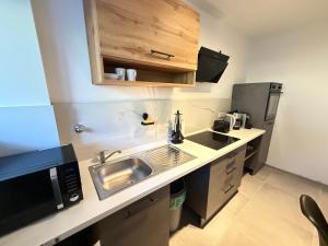 a small kitchen with a sink and a microwave at Business Apartment City 5 Betten & Parkplatz in Lüdenscheid