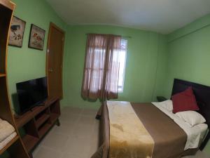 a bedroom with a bed and a flat screen tv at Casa León in Orizaba