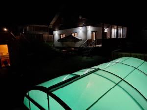 a green tent in front of a house at night at Wellness chata Rybárie in Klokočov