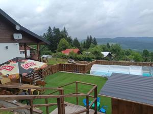 a backyard with a pool and a table and chairs at Wellness chata Rybárie in Klokočov