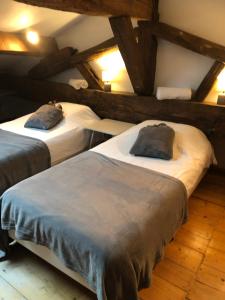 two beds in a room with wooden floors at La Vie de Château , Or du Temps in Ars-sur-Formans