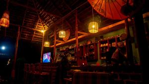 a restaurant with a bar with a television and lights at Amoy River Lodge in Moshi