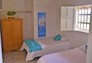 a bedroom with two beds and a cabinet and a window at Hermosa Finca Con Piscina y Jacuzzi in El Peñol +46 photos