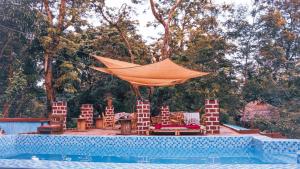 an orange canopy over a pool with chairs and a table at Amoy River Lodge in Moshi