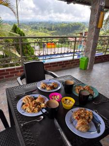 a table with plates of food on it with a view at Rancho Akila in Filandia