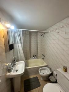 a bathroom with a sink and a toilet and a bath tub at Espacio necochea in Mendoza
