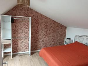 a bedroom with a red bed and a wall at La Pause Loonoise in Loon-Plage