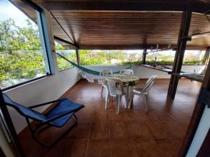 a room with a hammock and a table and chairs at Brisas da Cocanha in Caraguatatuba