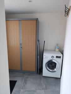 a laundry room with a washing machine and a closet at La Pause Loonoise in Loon-Plage