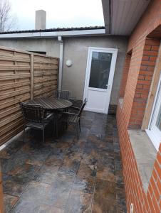 a patio with a table and chairs and a door at La Pause Loonoise in Loon-Plage