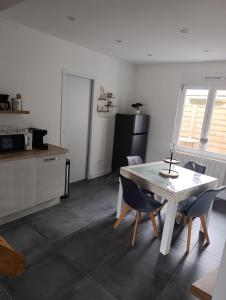 a kitchen with a table and chairs in a room at La Pause Loonoise in Loon-Plage